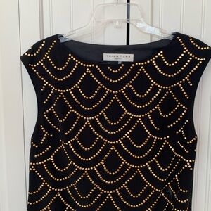 Trina Turk black silk small cap sleeve dress with gold scalloped brads detail.